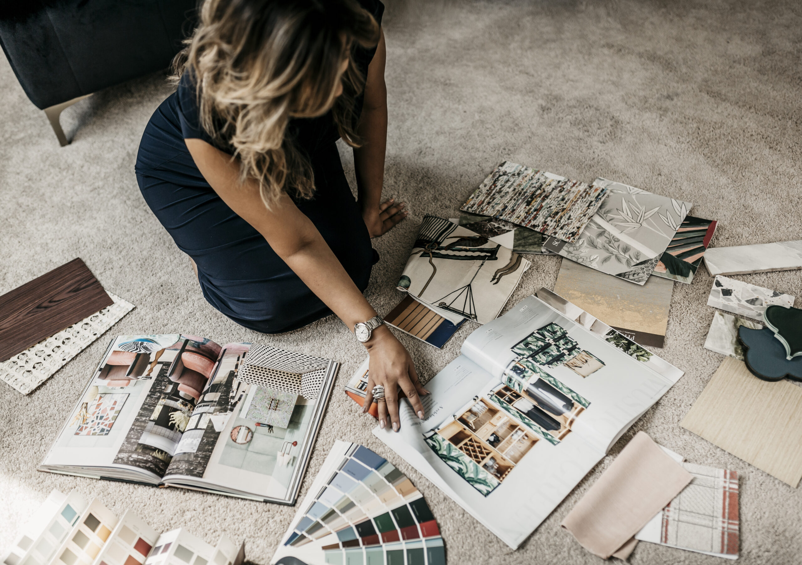 Rydhima Brar reviewing interior design materials, fabric samples and inspiration books.